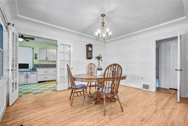 521 W Whiting Ave, Fullerton, CA 92832 - dining room with a chandelier, light wood-type flooring, french doors, wainscoting, and a ceiling fan