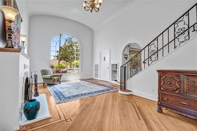 521 W Whiting Ave, Fullerton, CA 92832 - entryway featuring stairs, a chandelier, wood finished floors, arched walkways, and high vaulted ceiling