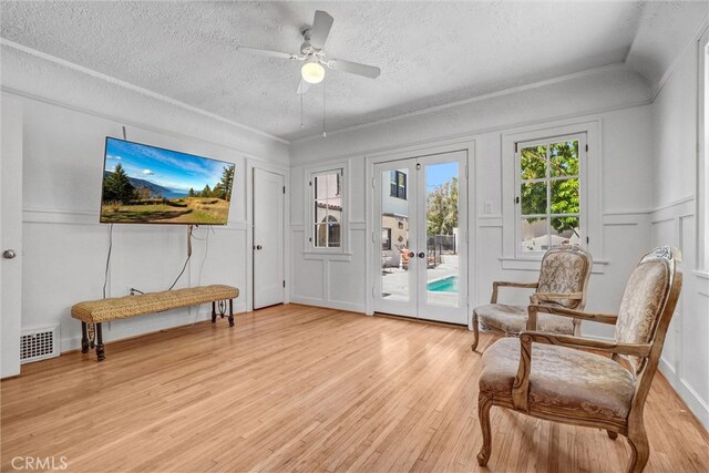 521 W Whiting Ave, Fullerton, CA 92832 - living area featuring french doors, a textured ceiling, light wood finished floors, ceiling fan, and a decorative wall