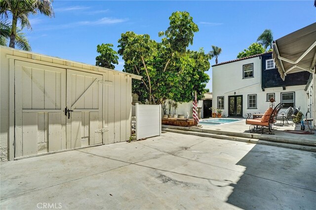 521 W Whiting Ave, Fullerton, CA 92832 - view of patio / terrace featuring a storage unit and an outdoor pool