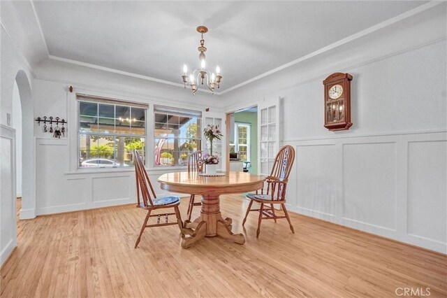 521 W Whiting Ave, Fullerton, CA 92832 - dining space featuring a decorative wall, a chandelier, light wood-type flooring, arched walkways, and wainscoting