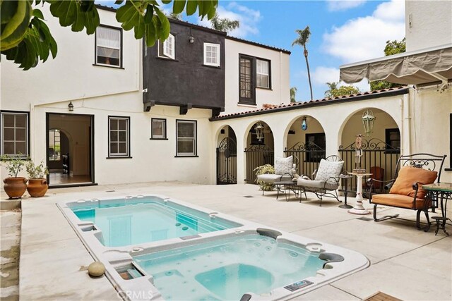 521 W Whiting Ave, Fullerton, CA 92832 - rear view of property with an in-ground hot tub, stucco siding, a patio, and an outdoor pool