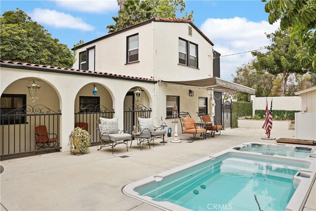 521 W Whiting Ave, Fullerton, CA 92832 - rear view of property with an in-ground hot tub, stucco siding, a patio, and a tile roof