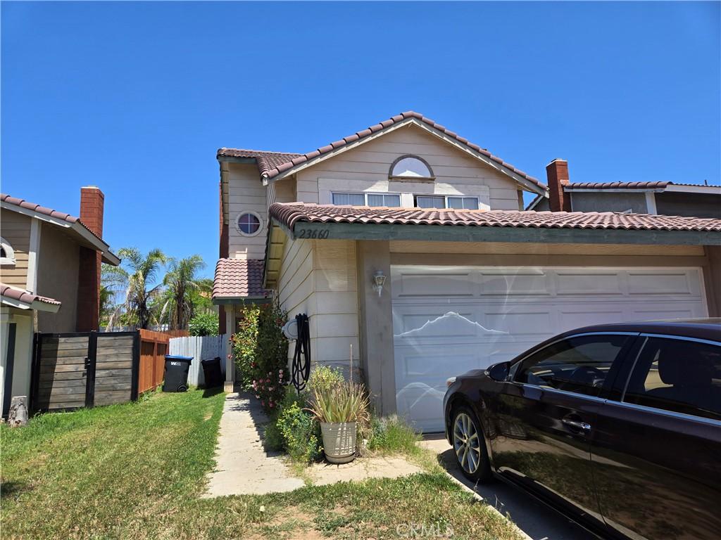 23660 Parkland Ave, Moreno Valley, CA 92557 - view of front facade with a garage, a tile roof, fence, and driveway