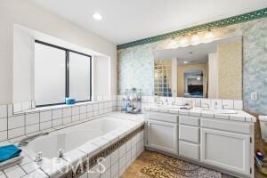full bathroom with wallpapered walls, a garden tub, double vanity, and recessed lighting