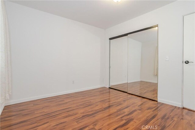 28083 Langside Ave, Canyon Country, CA 91351 - unfurnished bedroom with wood finished floors, baseboards, and a closet
