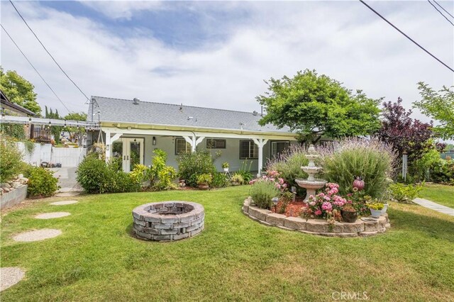 28083 Langside Ave, Canyon Country, CA 91351 - back of house featuring an outdoor fire pit, roof with shingles, and stucco siding