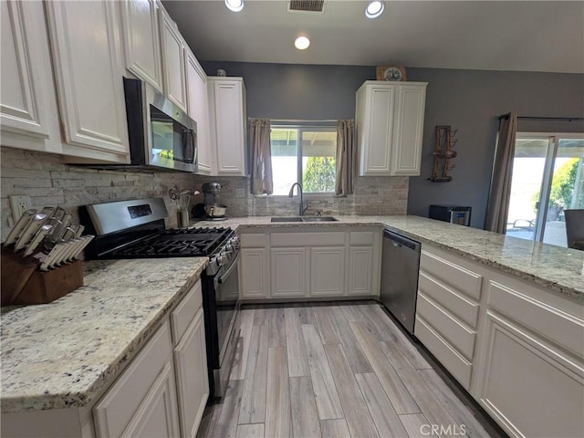 22132 Esaws Rd, Apple Valley, CA 92307 - kitchen with appliances with stainless steel finishes, a sink, recessed lighting, white cabinets, and decorative backsplash