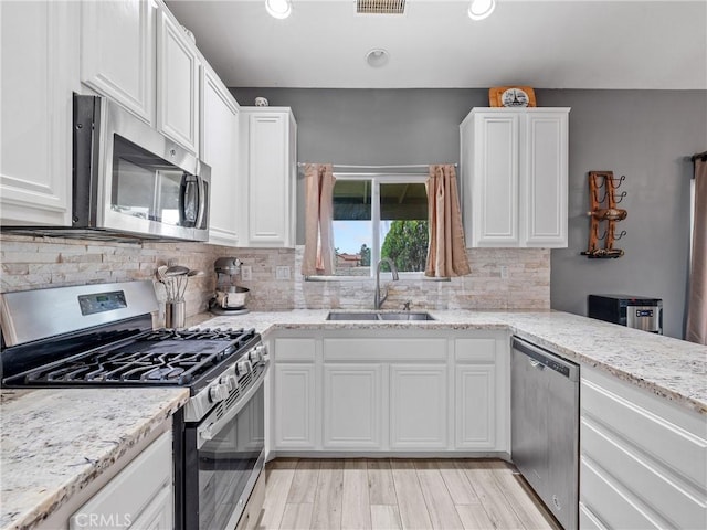 22132 Esaws Rd, Apple Valley, CA 92307 - kitchen featuring appliances with stainless steel finishes, a sink, white cabinetry, decorative backsplash, and recessed lighting