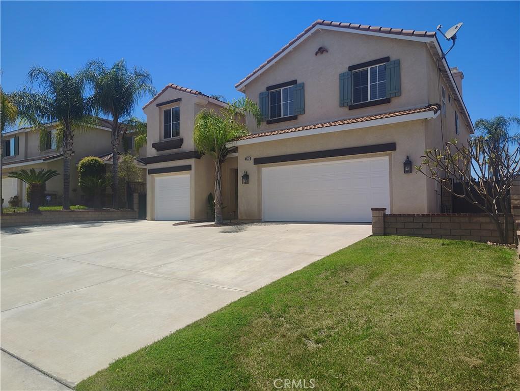 mediterranean / spanish-style house with a garage, stucco siding, driveway, a front yard, and a tile roof