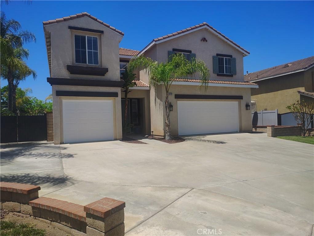 view of front of home featuring a garage, stucco siding, concrete driveway, and a tile roof