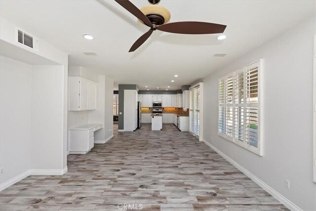 8433 Lindenhurst St, Riverside, CA 92508 - kitchen featuring stainless steel microwave, ceiling fan, white cabinets, freestanding refrigerator, and recessed lighting