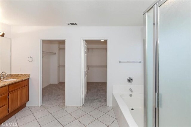 8433 Lindenhurst St, Riverside, CA 92508 - full bath with vanity, a bath, a spacious closet, a stall shower, and tile patterned flooring