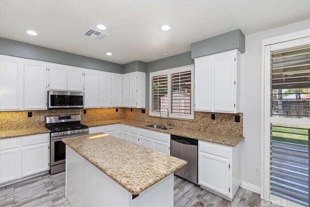 8433 Lindenhurst St, Riverside, CA 92508 - kitchen featuring appliances with stainless steel finishes, white cabinets, light stone countertops, and recessed lighting