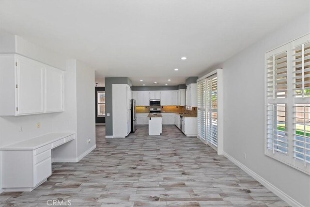 8433 Lindenhurst St, Riverside, CA 92508 - kitchen with appliances with stainless steel finishes, plenty of natural light, light wood-type flooring, white cabinets, and recessed lighting