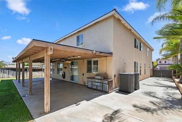 8433 Lindenhurst St, Riverside, CA 92508 - back of house featuring stucco siding, a patio area, ceiling fan, a fenced backyard, and exterior kitchen