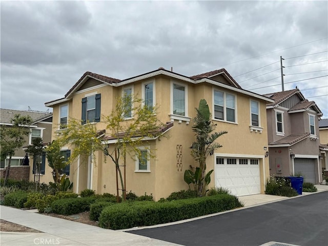 16548 Monteviejo St, Fontana, CA 92336 - townhome / multi-family property with a tile roof, stucco siding, a garage, and driveway