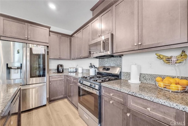 16548 Monteviejo St, Fontana, CA 92336 - kitchen featuring appliances with stainless steel finishes, light wood-type flooring, and light stone countertops
