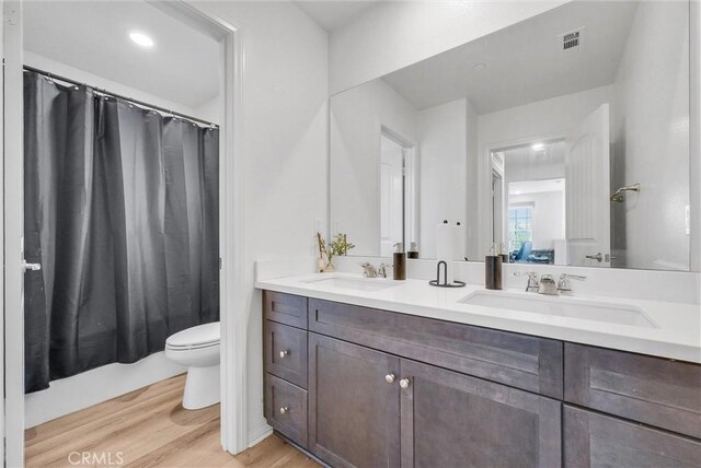 16548 Monteviejo St, Fontana, CA 92336 - full bathroom featuring wood finished floors, toilet, and double vanity