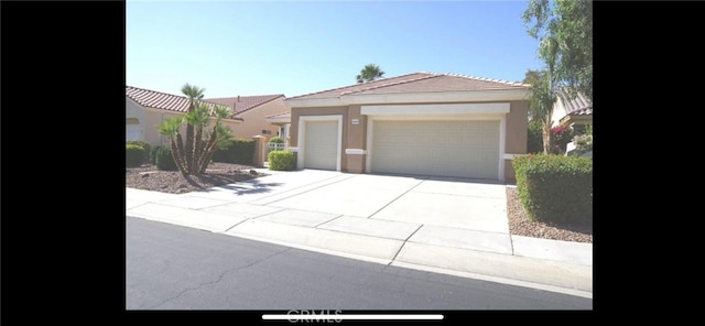 78379 Kistler Way, Palm Desert, CA 92211 - view of front of house with driveway, stucco siding, a tiled roof, and an attached garage
