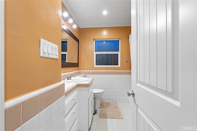 14725 Kornblum Ave, Hawthorne, CA 90250 - bathroom featuring toilet, tile patterned floors, vanity, a wainscoted wall, and tile walls
