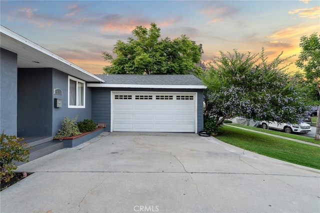 14725 Kornblum Ave, Hawthorne, CA 90250 - garage at dusk featuring concrete driveway and a yard