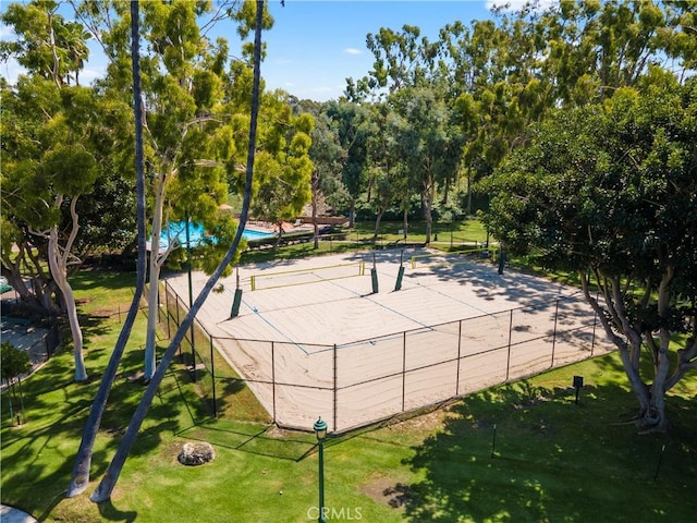 view of property's community with volleyball court and view of scattered trees