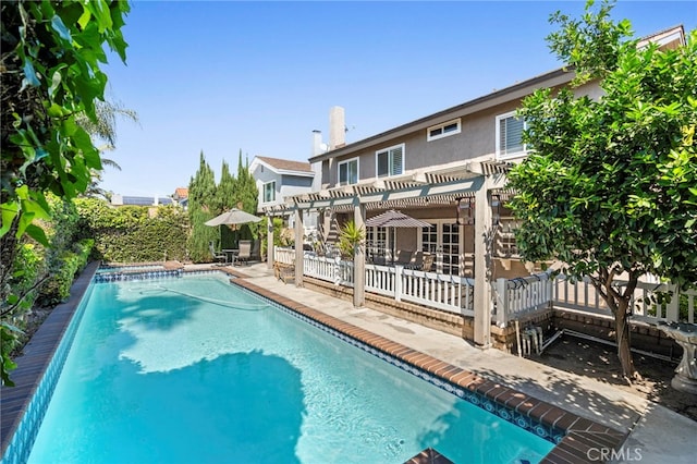 view of swimming pool featuring a pergola, a patio, fence, and a pool with connected hot tub