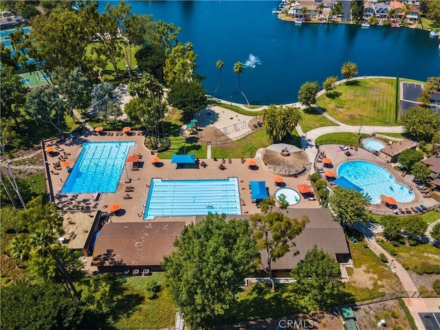 drone / aerial view of a pool and a nearby body of water