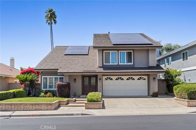 traditional-style home with a garage, solar panels, concrete driveway, and stucco siding