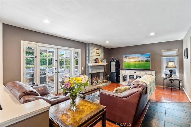 living area with recessed lighting, a fireplace, dark tile patterned floors, and baseboards