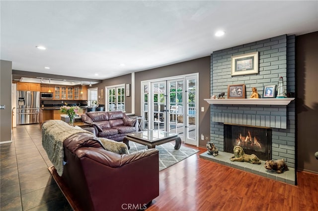 living room featuring baseboards, a fireplace, and recessed lighting