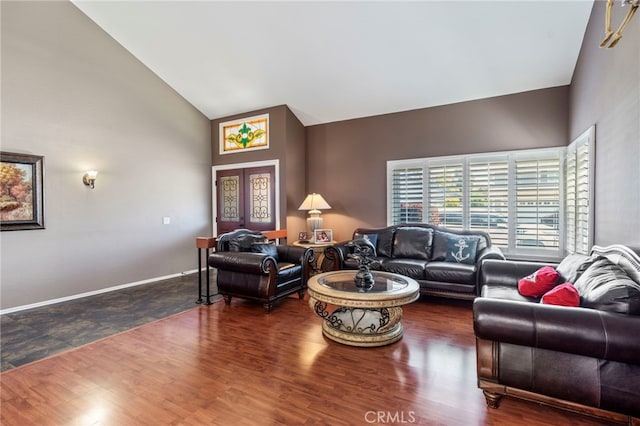 living area featuring wood finished floors, high vaulted ceiling, and baseboards
