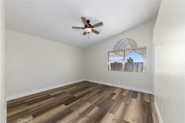 spare room featuring wood finished floors, a ceiling fan, baseboards, and lofted ceiling