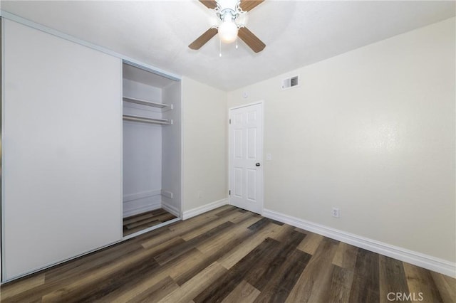 unfurnished bedroom with wood finished floors, baseboards, a closet, and ceiling fan