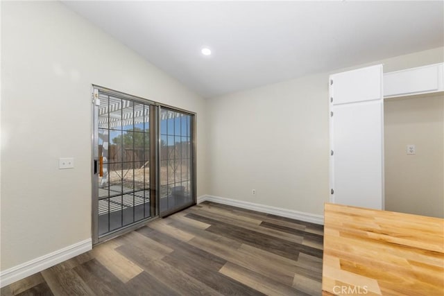 empty room with baseboards, dark wood-style flooring, lofted ceiling, and recessed lighting