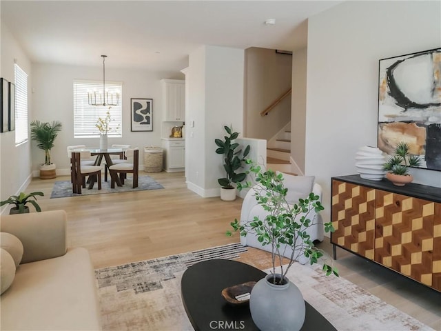 613 E Walnut Ave, Monrovia, CA 91016 - living room with stairs, light wood-type flooring, a chandelier, and baseboards