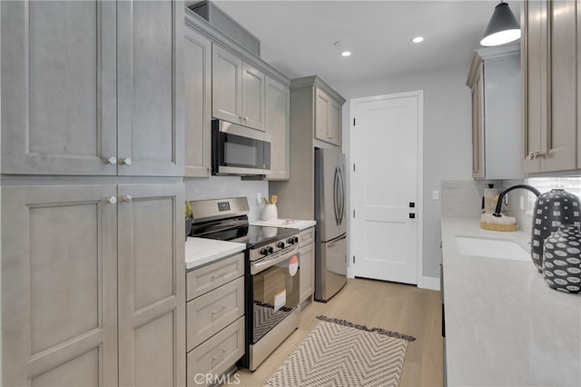 613 E Walnut Ave, Monrovia, CA 91016 - kitchen with stainless steel appliances, light wood-style flooring, gray cabinetry, recessed lighting, and tasteful backsplash