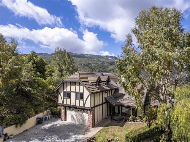 24300 Sylvan Glen Rd, Calabasas, CA 91302 - view of front of home with an attached garage, decorative driveway, and brick siding