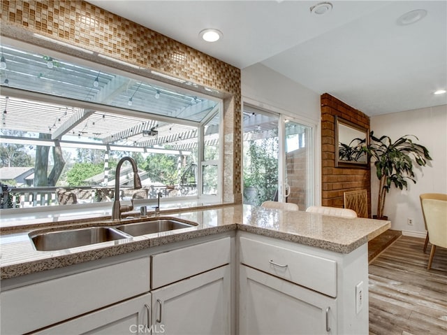 6587 E Via Fresco, Anaheim Hills, CA 92807 - kitchen with a sink, light wood-type flooring, white cabinets, light stone countertops, and recessed lighting
