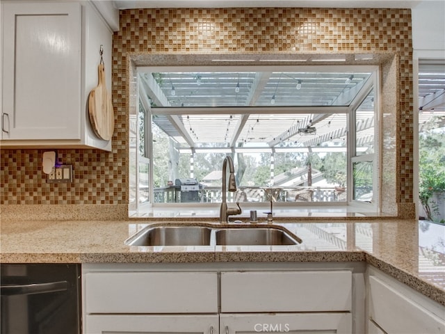 6587 E Via Fresco, Anaheim Hills, CA 92807 - kitchen featuring a sink, white cabinetry, tasteful backsplash, dishwashing machine, and light stone counters