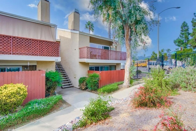 view of building exterior featuring stairs and fence