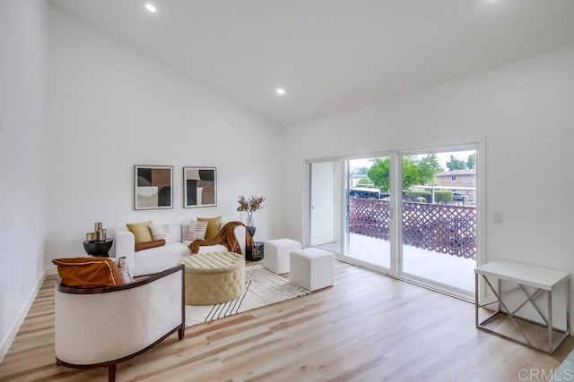 living room featuring wood finished floors, recessed lighting, high vaulted ceiling, and baseboards