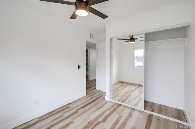 unfurnished bedroom with light wood-style flooring, a closet, ceiling fan, and baseboards