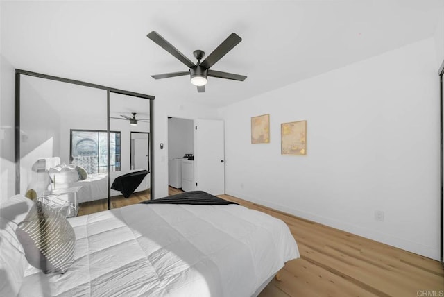 bedroom featuring washer and dryer, light wood-style flooring, baseboards, and ceiling fan
