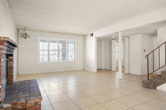 2575 Gayle Pl, Simi Valley, CA 93065 - unfurnished living room with a textured ceiling, stairs, a fireplace, and light tile patterned flooring