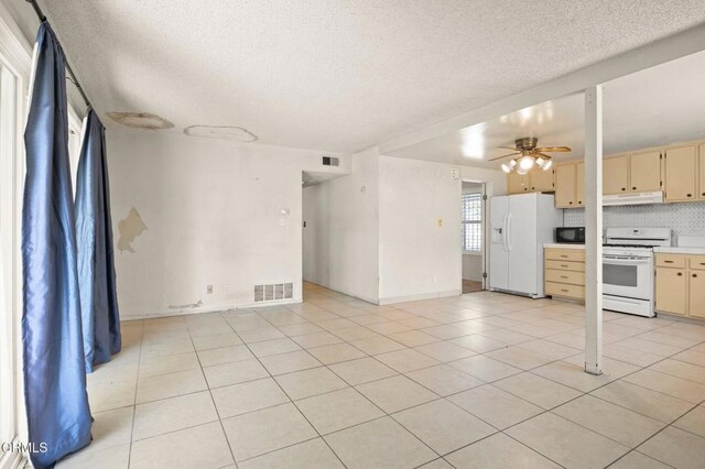 2575 Gayle Pl, Simi Valley, CA 93065 - kitchen with white appliances, light countertops, a textured ceiling, light tile patterned floors, and cream cabinets