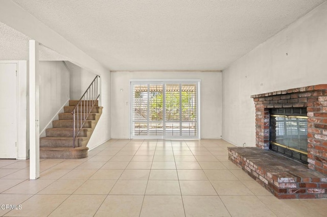 2575 Gayle Pl, Simi Valley, CA 93065 - unfurnished living room with a textured ceiling, a brick fireplace, tile patterned flooring, and stairs