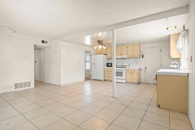 2575 Gayle Pl, Simi Valley, CA 93065 - kitchen with white appliances, under cabinet range hood, tile counters, a sink, and a textured ceiling