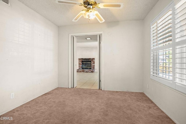 2575 Gayle Pl, Simi Valley, CA 93065 - empty room featuring carpet floors, healthy amount of natural light, a ceiling fan, a textured ceiling, and a brick fireplace